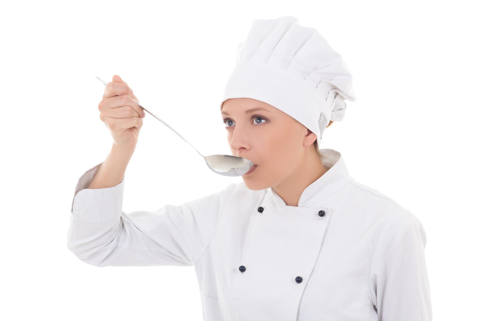 Chef adjusting seasoning in a test kitchen
